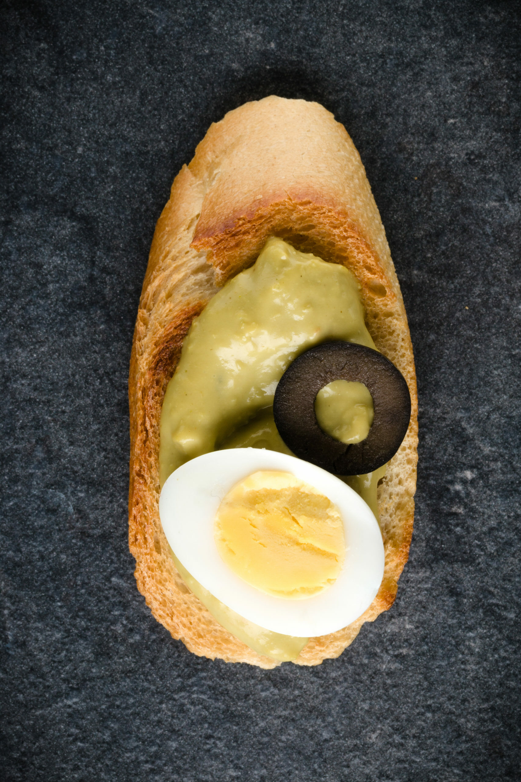 Open faced sandwich canape or crostini on dark stone background